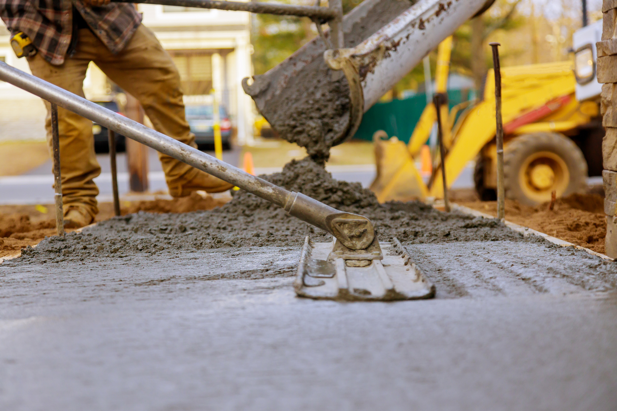 Concrete being poured and leveled on a construction site