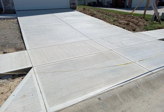 Newly finished concrete driveway leading to a garage