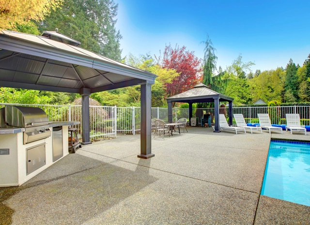 Concrete patio with outdoor kitchen and a swimming pool
